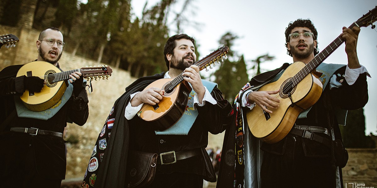 Tunos tocando guitarras en una actuacion al aire libre